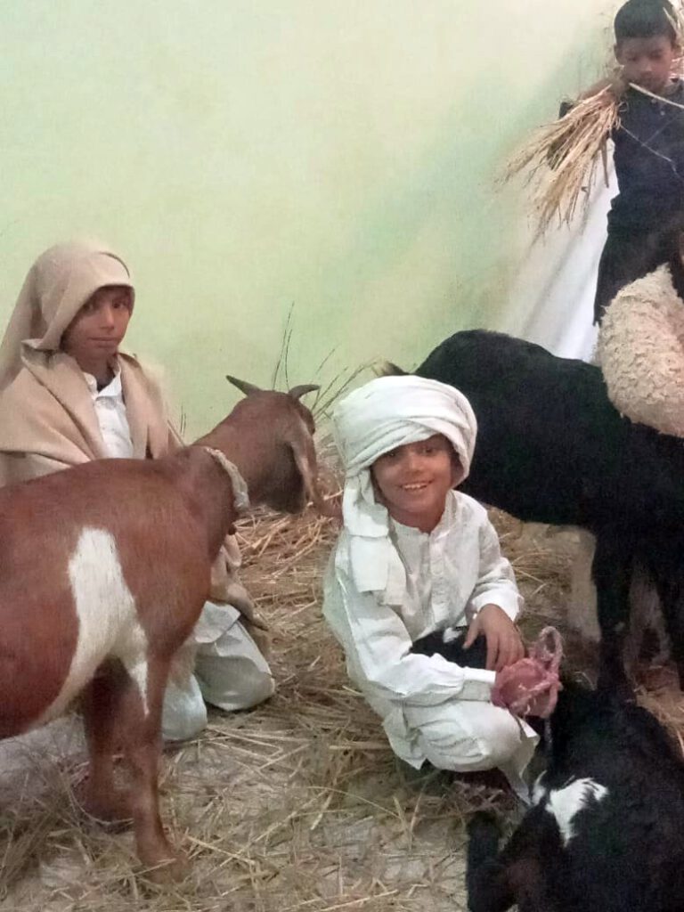 3 Kinder als Hirten verkleidet mit 3 Ziegen